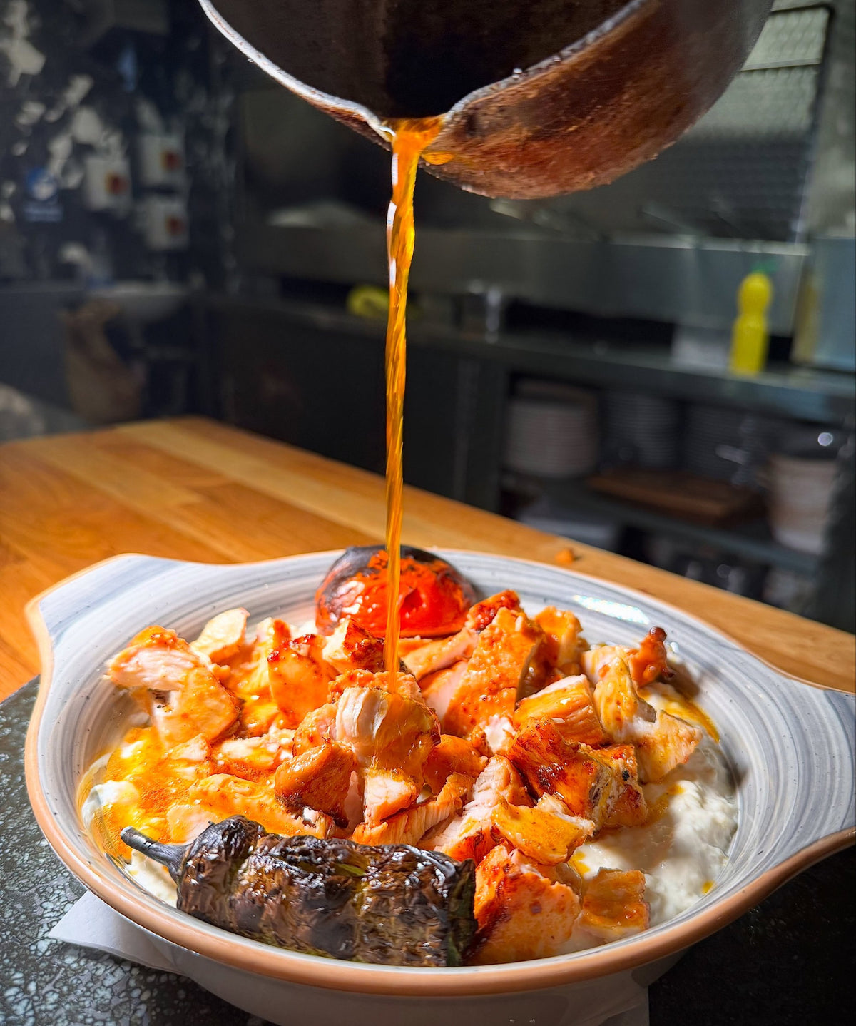Sizzling butter poured over a chef's special at LARA KITCHEN